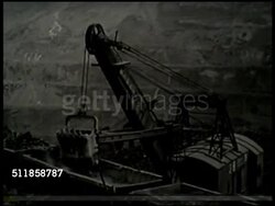 1933: MANCHUKUO: MINING: WS Mining tower w/ conveyor loader, HA WS Front loader loading ore into coal bins at Fushin colliery. VS Manchurian Chinese workers, making holes, using pick axes on ore rocks, in coats eating rice from bowls, single male eating. Instructional Video