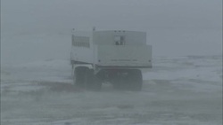 A large vehicle climbs over bumps in a wintery landscape. Stock Footage