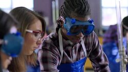 Teacher assists students using tablet to conduct lab Stock Footage