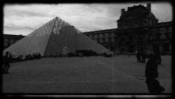 Pedestrians pass by the Louvre Pyramid outside the museum. Stock Footage
