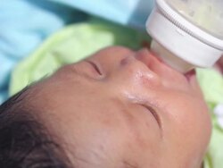 Baby infant suckling milk from bottle Stock Footage