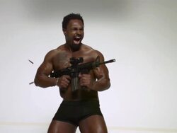 MS SLO MO Shot of black African American male with MR27 machine gun firing bullets coming out of side of gun / Studio, New York, United States Stock Footage