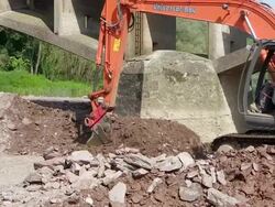 MS TS Shot of construction waste material immersing into water at bridge construction site preparing demolition of old bridge / Wiltingen, Rhineland Palatinate, Germany Stock Footage