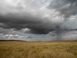 Pan left and right of wind farm on prairie with very dramatic clouds in sky. Stock Footage