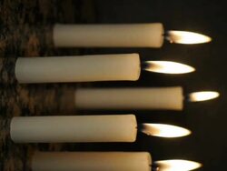 T/L five white wax candles burning down on polished granite surface Stock Footage