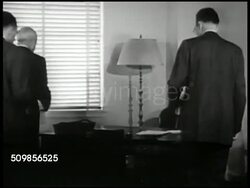 1947: U.S. TRAINS MODERNIZATION: MS Industrialist Robert R. Young standing w/ man & paper work. MS Man brings Young newspaper, reading. VS Young &men at desk looking, talking over paper. CU Headlines 'Why the Railroads Can't Afford NOT to Modernize!' Instructional Video