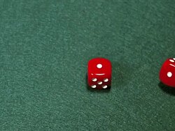CU SLO MO Red dice rolling against green background / Vieux Pont, Normandy, France Stock Footage