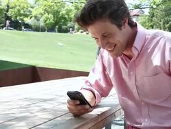 MS Well dressed young man using  cell phone deviceand smiling  outside in park on sunny day / Minneapolis, Minnesota, United States Stock Footage