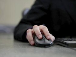 Bank teller using computer mouse and keyboard in bank Stock Footage