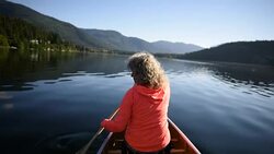 Senior Woman canoeing on a pristine lake Stock Footage