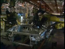 MS Robots working on cars in factory production line Stock Footage