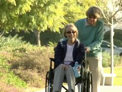 Pushing wheelchair in park HD video Stock Footage