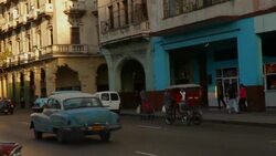 MS of Cuban street with vintage cars & pedestrians Stock Footage