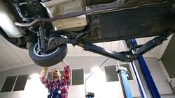 Car mechanic working under a vehicle. Stock Footage