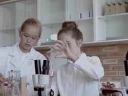 MS Two schoolgirls working with test tubes and beacons in school lab Stock Footage