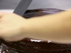CU Shot of pastry chef spreading chocolate glaze over Sacher Torte cake / Rome, Lazio, Italy Stock Footage
