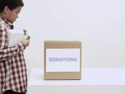 Boy putting food donations in box Stock Footage