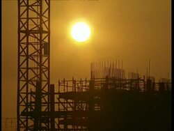 MCU Crane, tower and building site structures silhouetted by afternoon sun Stock Footage