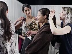 MS Stylist making final adjustments on female models hair backstage at fashion show  Stock Footage