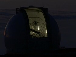 Medium static - Clouds float behind a lit telescope at the W. M. Keck Observatory in Mauna Kea, Hawaii at night. / Mauna Kea, Hawaii, USA Stock Footage