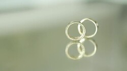 Wedding Rings on glass table Stock Footage