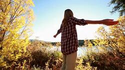Young cheerful woman arms outstretched in nature Stock Footage