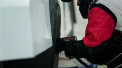 A pit crewman tightens the lug nuts on a stock car. Stock Footage