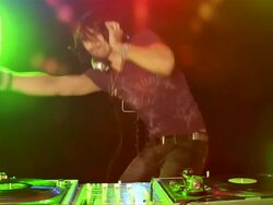 Handheld medium shot young man dj spinning records, listening to headphones, dancing Stock Footage