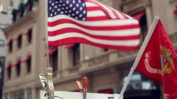 American flag waves over street vendor sign for $5 designer jewelry on New York City street Stock Footage