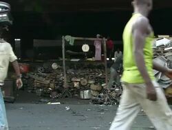 MS Shot of pedestrians passing in front of collection and weighing building for scrap metal / Lagos, Nigeria Stock Footage