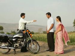 Salesman giving keys of motorcycle to a rural couple  Stock Footage