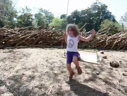 MS Little girl pushes herself on swing in natural playground / Montezuma, Nicoya Peninsula, Costa Rica  Stock Footage