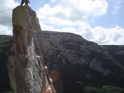 Young woman pulls herself across Tyrolean traverse Stock Footage