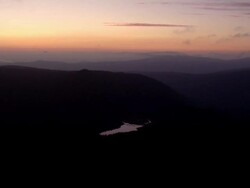 Mountain lake reflecting a golden sunset Stock Footage
