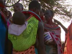 Maasai Ceremony - Women apply red face paint in preparation for ceremony, WITH AUDIO Stock Footage