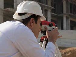 Architect lookiing through theodolite instrument in the construction site, Delhi, India Stock Footage