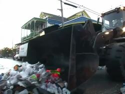 Medium Shot Pan Left - Garbage truck sweeping trash down the street / New Orleans Louisiana Stock Footage