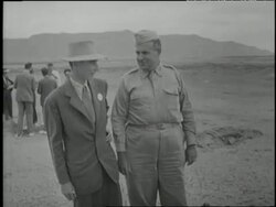 Scientist J. Robert Oppenheimer and U.S. General Leslie Groves talk together at an atomic test site in Los Alamos, New Mexico. News Clip