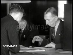 1945: ENGLAND MANPOWER: EXT Men entering recruitment building. INT Men on line, 'Registration.' VS Men conversing, signing up at registration booth. EXT MS English soldiers in gear marching, boarding ship via ramp, gangplank, descending stairs. Instructional Video