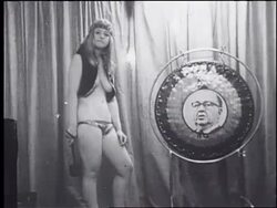 Scantily clad hippie woman bangs gong with a picture of Chicago Mayor Richard Daley on it. Stock Footage