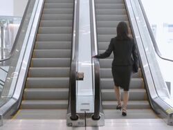  WS Businesswoman ascending escalator in office building / Seattle, Washington, United States Stock Footage