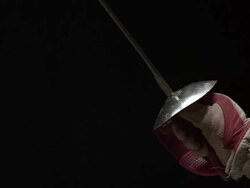 Close up of man holding foil and leaping foward in fencing uniform Stock Footage