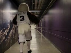 MS basketball eagle mascot running down hallway of basketball stadium with arms in air rear view / Washington, USA Stock Footage