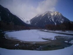 T/L clouds passing over snowy valley with river in foreground, Kamikochi, Japan Stock Footage