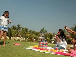 Man talking photograph with a camera of his daughter doing hula hoop in a park  Stock Footage