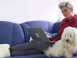 HD: Woman Using Laptop And Cuddling Her Dog Stock Footage
