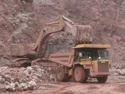 MS Excavator truck loading stone in another truck at quarry / Taben-Rodt, Rhineland-Palatinate, Germany Stock Footage