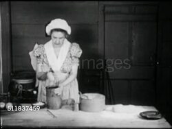 MOT: EARLY AMERICANA: HOMEMAKING REENACTMENT: Woman in period clothing long dress at kitchen work table placing course salt into handmade wooden mortar & pestle, pounding salt. Instructional Video