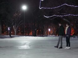 Caucasian couple skates together on a winter night. Stock Footage
