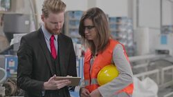Quality inspector and worker talking in the factory and using tablet pc Stock Footage